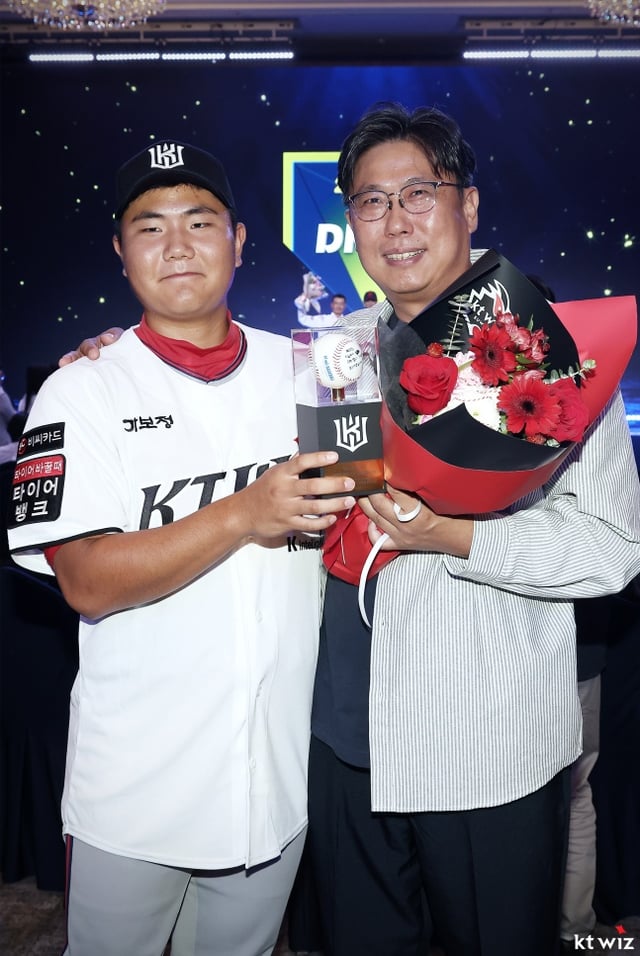 KT 3라운드 지명자 충암고 김지율이 21일 서울 송파구 롯데호텔 월드 크리스탈볼룸에서 열린 '2027 KBO 신인 드래프트'에서 첫 사인공을 들고 아버지와 미소 짓고 있다. /사진=KT 위즈 제공