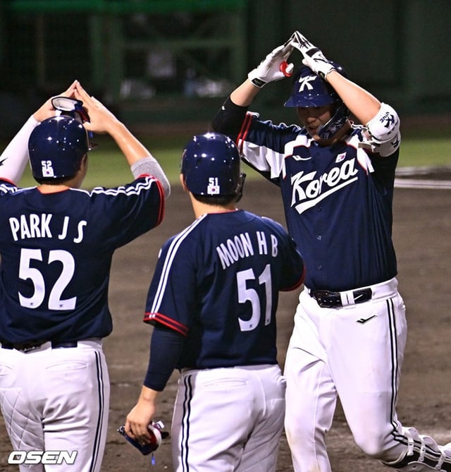 Cho Hyung-woo (derecha) de la selección coreana de béisbol realiza una celebración tras conectar un jonrón con las bases llenas en el tercer inning inferior del segundo partido de la fase de grupos del Grupo B de los Juegos Asiáticos Aichi-Nagoya 2026 contra Hong Kong, celebrado el día 22 en el estadio municipal de Toyohashi, prefectura de Aichi, Japón.