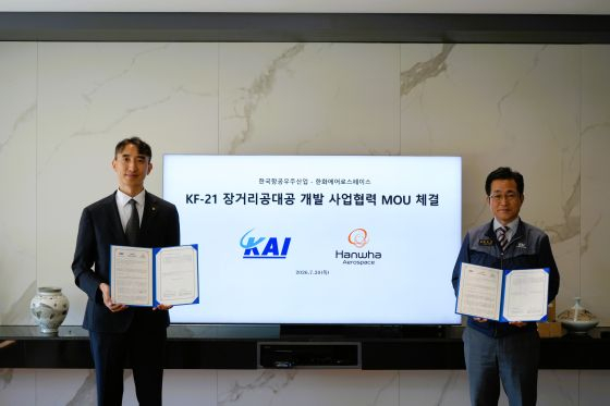 7월 경남 사천시 한국항공우주산업(KAI) 본사에서 열린 KF-21 장거리 공대공 개발 사업협력 MOU 체결식에서 백기봉 한화에어로스페이스 PGM2사업단장과 백중현 KAI 국내사업본부 고정익사업1실장이 기념촬영하고 있다/사진제공=한화에어로
