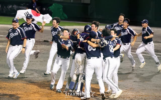 선발투수 곽빈과 대한민국 야구대표팀 선수들이 27일 일본 아이치현 도요하시 시민구장에서 열린 2026 아이치·나고야 야구 슈퍼라운드 한국과 일본 결승전 9회말 수비를 마무리하며 금메달을 확정한 후 환호하고 있다. 응원석에서 휘날리는 대형 태극기 2026.09.27. 선발투수 곽빈과 대한민국 야구대표팀 선수들이 27일 일본 아이치현 도요하시 시민구장에서 열린 2026 아이치·나고야 야구 슈퍼라운드 한국과 일본 결승전 9회말 수비를 마무리하며 금메달을 확정한 후 환호하고 있다. 2026.09.27. /사진=강영조 cameratalks@