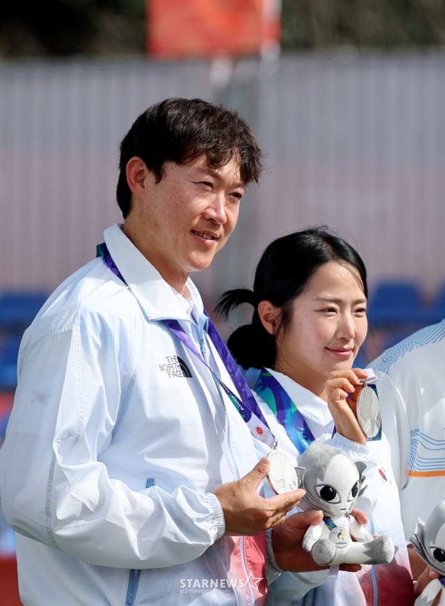 大韓民国のパク·ジョンユン-チェ·ヨンヒが30日、日本の岡崎中央そごう公園で開かれた2026愛知·名古屋アジア大会アーチェリーコンパウンド混合ダブルスインドとの決勝戦シュートオフで最後の矢が9点を記録し、惜しくも銀メダルにとどまった。 2026.09.29.最後のチェ·ヨンヒの点数が9と表示されると···残念なパク·ジョンユン、チョン·ウィソンアーチェリー協会会長が授賞後、選手たちと記念撮影をしている。 「私も残念!」/写真=カン·ヨンジョcameratalks@