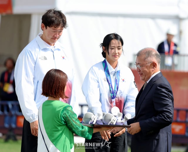 대한민국 박정윤-최용희가 30일 일본 오카자키 주오 소고 공원에서 열린 2026 아이치·나고야 아시안게임 양궁 컴파운드 혼합복식 인도와의 결승전 슛오프에서 마지막 화살이 9점을 기록하며 아쉽게 은메달에 머물렀다. 정의선 양궁협회회장이 두 선수에게 은메달을 걸어주고 있다. . 2026.09.29. /사진=강영조 cameratalks@