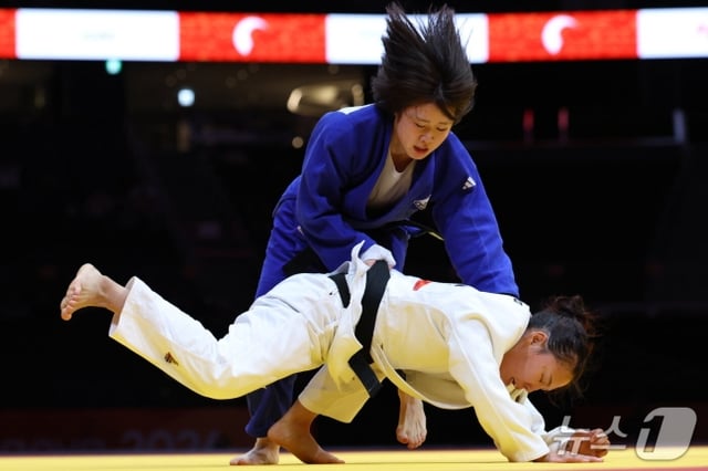 ホ·ミミ(上)が1日、日本愛知インターナショナルアリーナで開かれた2026愛知·名古屋アジア大会柔道女子57㎏級決勝でモンゴル代表テルビシ·アリウンジャヤと正面対決を繰り広げている。 /写真=ニュース1