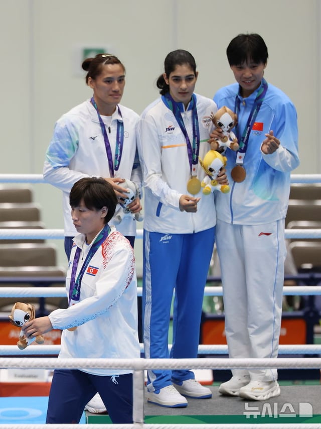 2026 아이치·나고야 아시안게임 복싱 여자 65kg 시상식에서 동메달을 획득한 북한 황효순이 다른 메달 수상자들과의 손하트 기념촬영을 거부하고 자리를 이동하고 있다. /사진=뉴시스