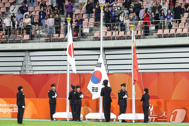 2026 아이치·나고야 아시안게임 남자축구 시상식에서 관계자들이 정상적으로 게양되지 않은 태극기를 정리하고 있다. 다른 국기들이 올라간 가운데 태극기만 제대로 게양되지 않는 상황이 발생했다. /사진=뉴스1 제공