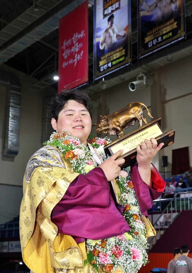 Kim Min-jae posa sosteniendo el toro dorado tras derrotar a Ma Gwon-su en la final del campeón Baekdu (hasta 140 kg) del Torneo de Ssireum de Campeones de Chuseok de Goeosan 2026, patrocinado por Withers Pharmaceutical, celebrado el día 11 en el Centro Cultural y Deportivo de Goeosan, en la provincia de Chungcheong del Norte. /Foto=Asociación Coreana de Ssireum