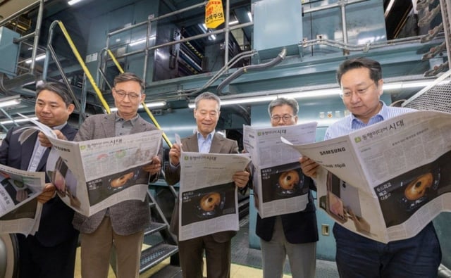 同行メディア時代の新聞発行を翌日に控えた14日、ソウル松坡区（ソンパグ）の中央（チュンアン）日報江南（カンナム）社屋の輪転室で、同行メディア時代の洪善根（ホン·ソングン）会長ら役職員が時代初の新聞を読んでいる。 左からソン·ジョンヨル経営戦略·マーケティング本部長、チョン·ヨングァン主筆、ホン会長、オ·ビョンサン代表、イ·サンオン編集局長。/写真=同行メディア時代