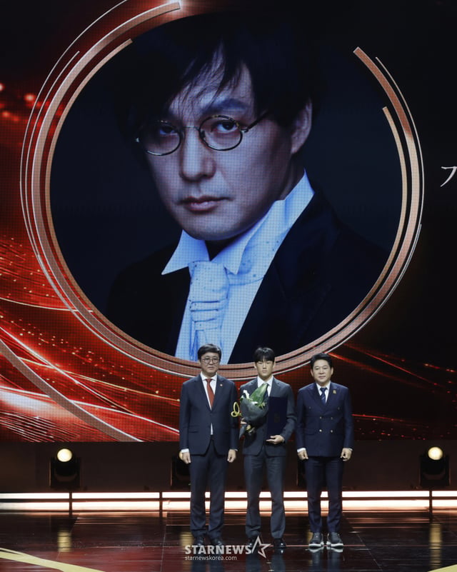 [Seúl=NEWSIS] La reportera Kim Hye-jin = Choi Hui-young, ministra del Ministerio de Cultura, Deportes y Turismo (desde la izquierda), Shin Dong-won, hijo del difunto Shin Hae-cheol, y Park Sang-cheol posan para una foto conmemorativa durante la 17.ª edición del Premio a las Artes y la Cultura Popular de Corea, celebrado el día 29 en el Teatro Nacional de Seúl, en el distrito de Jung-gu. El Premio a las Artes y la Cultura Popular, que alcanza su 17.ª edición este año, es la máxima distinción gubernamental en el ámbito de las artes y la cultura popular, creada para elevar el estatus social y el impulso creativo de los artistas populares y para honrar la contribución de quienes han impulsado el desarrollo de la industria de las artes y la cultura popular. 2026.10.29. jini@newsis.com /foto=Kim Hye-jin