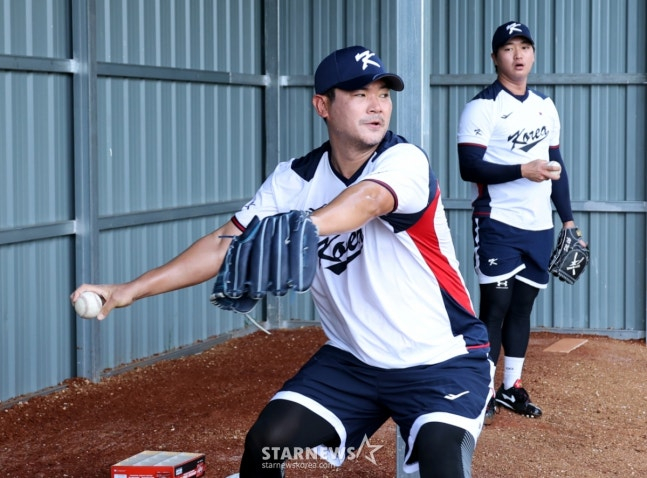Noh Kyung-eun (left) is pitching the bullpen. In the back, Ko Woo-seok is looking curiously. /Photo = Senior Reporter Kang Young-jo