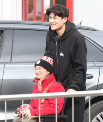 =金珉载（右）为坐在轮椅上的粉丝下车拍照。