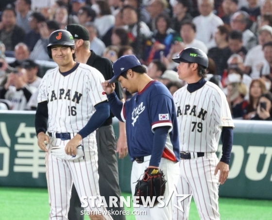 7日，在东京巨蛋体育场举行的2026WBC东京POOL韩国队与日本队的比赛第5回合末，韩国一垒手文宝京（中）正在向安打出垒的大谷致意。 =照片=高级记者姜英祖。  