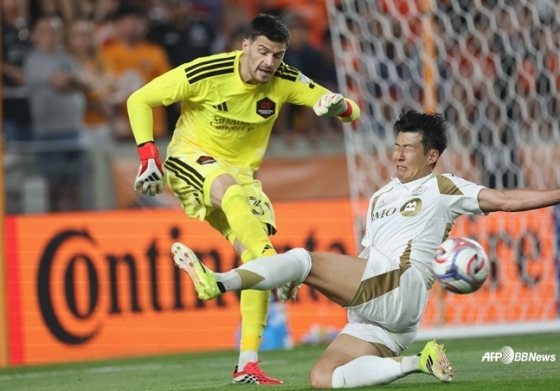 孫興民（ソン·フンミン、右）が1日（韓国時間）、米テキサス州ヒューストンのシェルエネルギースタジアムで行われた2026米プロサッカー·メジャーリーグサッカー（MLS）第2ラウンドの試合中、相手GKにタックルを試みている。 /AFPBBNews=ニュース1