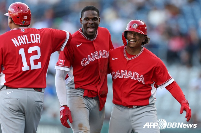 Denzel Clark của Canada (giữa) đang vui mừng sau khi ghi bàn trong trận chung kết bảng A vòng 1 của trận chung kết WBC 2026 được tổ chức tại Estadio Hirambison ở San Juan, Puerto Rico vào ngày 12 (giờ Hàn Quốc)./AFPBBNews = Tin tức 1