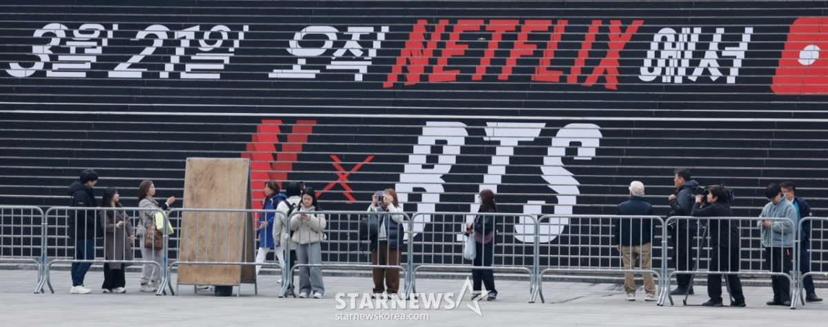 （ソウル=ニュース1）アン·ウンナ記者=BTS(BTS)カムバックライブARIRANG(アリラン)を控えた16日、ソウル鍾路区光化門広場が舞台設置で統制された中でファンがこれを撮影している。 2026.3.16/ニュース1 Copyright © ニュース1. All rights reserved。無断転載及び再配布、AI学習利用禁止。 /写真=（ソウル=ニュース1）アン·ウンナ記者